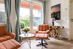 Helles Wohnzimmer mit orangefarbenen Sesseln - Haus Windflüchter - Top-Hundeurlaub