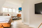 Schlafzimmer mit Bett und Sitzbereichen - Haus Windflüchter - Top-Hundeurlaub