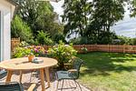 Terrasse mit Holztisch und Stühlen, blühenden Hortensien und eingezäuntem Garten. - Boddenblick 1 - Top-Hundeurlaub