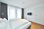 Schlafzimmer mit Doppelbett und Zugang zum Balkon - Deichhäuser Anna Küste 4-24 - Top-Hundeurlaub
