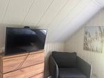 Schlafzimmer mit Fernseher und Sitzecke – Villa Waldsee Ferienhaus am See - Villa Waldsee - Top-Hundeurlaub