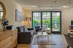 Wohnzimmer mit Sofa und Blick zur Terrasse - Wohnung 11-2 - Top-Hundeurlaub