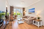 Wohnbereich mit Sitzecke und TV - Wohnung 01 - Top-Hundeurlaub