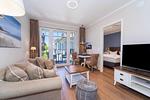 Wohnbereich mit Sitzecke und TV - Wohnung 05 - Top-Hundeurlaub