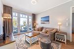 Wohnzimmer mit Sofa und Blick zum Balkon - Wohnung 42 - Top-Hundeurlaub