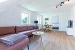 Helles Wohnzimmer mit Sofa und Esstisch - Boddenräuber 4 - Top-Hundeurlaub