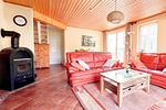 Heller Wohnbereich mit roter Ledercouch im Seebad Kölpinsee - Ferienwohnung 3 - Top-Hundeurlaub