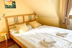 Ruhiges Schlafzimmer mit Doppelbett und warmem Holzdekor - Ferienwohnung 3 - Top-Hundeurlaub