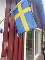 Schwedische Flagge am traditionellen roten Ferienhaus - Hus Rusken - Top-Hundeurlaub