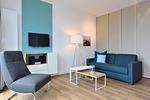 Wohn/ Essbereich mit Couch, Sessel und Fernseher - Aparthotel Anna Düne 2-31 - Top-Hundeurlaub