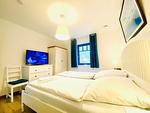 Gemütliches Schlafzimmer mit Fernseher und modernem Design für erholsame Nächte. - Haus Schiffchen - Top-Hundeurlaub