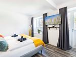 Schlafzimmer 1: Doppelbett (180x200), TV, Zugang zum Balkon - FeWo Unsere Perle in PRORA - 4.01 - Top-Hundeurlaub
