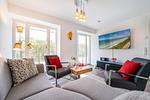 Wohn/Essbereich: Sofa, Flachbildfernseher, Zugang zum Balkon - FeWo Grumsin in PRORA - 4.21 - Top-Hundeurlaub