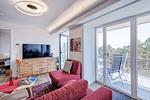 Wohnzimmer: Schlafsofa und Sessel, TV, Essbereich, Zugang zum Balkon - FeWo Seemelodie in PRORA - 9.43 - Top-Hundeurlaub
