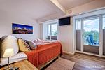 Schlafzimmer 1: Doppelbett (180x200), TV, Zugang zum Balkon - FeWo Strandidyll in PRORA - 9.31 - Top-Hundeurlaub