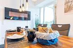 Wohn/Essbereich: Sofa, Sitzbereich, Essbereich, TV, Elektrokamin, Zugang zum Balkon - FeWo Meerlust in PRORA - 4.42 - Top-Hundeurlaub