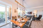 Wohn/Essbereich: Sofa, Sitzbereich, Essbereich, TV, Elektrokamin, Zugang zum Balkon - FeWo Meerlust in PRORA - 4.42 - Top-Hundeurlaub