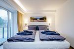 Schlafzimmer 1: Boxspringdoppelbett (180 x 200), TV, Zugang zum Balkon - FeWo Sandburg in PRORA - 9.01 - Top-Hundeurlaub