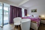 Schlafzimmer 1: Doppelbett (160x200), TV, Zugang zum Balkon - FeWo Seepferdchen in PRORA - 9.07 - Top-Hundeurlaub