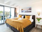 Schlafzimmer 1: Doppelbett (180 x 200), TV, Kleiderschrank, Verdunklungsgardinen, Zugang zum Balkon - FeWo Sternenblick Dachterrasse in PRORA - 4.54 - Top-Hundeurlaub