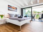 Schlafzimmer 1: Doppelbett (180x200), TV, Zugang zum Balkon, - Blick auf das Meer - FeWo Dünenheide 3.3 in PRORA - 7.33 - Top-Hundeurlaub