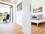 Schlafzimmer 1: Doppelbett (180x200), TV, Zugang zum Balkon, - Blick auf das Meer - FeWo Dünenheide 3.3 in PRORA - 7.33 - Top-Hundeurlaub