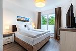 Schlafzimmer "1" mit Boxspringbett (1,80 x 2,00 m) und TV - Aparthotel Ostseeallee 5-46 - Top-Hundeurlaub