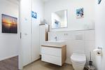 Badezimmer "1" mit Wschtisch, Spiegel und WC - Aparthotel Ostseeallee 5-46 - Top-Hundeurlaub