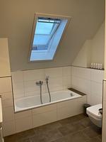 Badezimmer mit Badewanne, Dusche und Fenster. - Ferienhaus Nordlicht - Top-Hundeurlaub