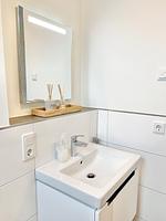 Modernes Badezimmer mit Waschbecken und Spiegel - Ferienhaus Nordlicht - Top-Hundeurlaub