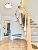 Eingangsbereich mit Holztreppe und Sitzbank - Ferienhaus Nordlicht - Top-Hundeurlaub