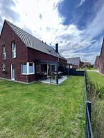 Außenansicht eines Hauses mit Rasen und Garten. - Ferienhaus Leo - Top-Hundeurlaub