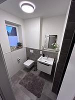 modernes Badezimmer mit Fenster und Waschbecken. - Ferienhaus Leo - Top-Hundeurlaub