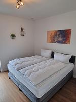 Schlafzimmer mit Doppelbett und Wanddekoration - Ferienhaus Brandungsperle - Top-Hundeurlaub