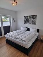 Schlafzimmer mit Doppelbett und Aussicht - Ferienhaus Brandungsperle - Top-Hundeurlaub