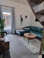 Heller Wohnraum mit Sofa und Tisch. - Ferienhaus Brandungsperle - Top-Hundeurlaub
