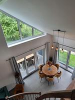 Helles Wohnzimmer mit Essbereich und großen Fenstern. - Ferienhaus Brandungsperle - Top-Hundeurlaub