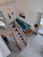 Elegantes Wohnzimmer mit Treppe und modernen Möbeln - Ferienhaus Brandungsperle - Top-Hundeurlaub