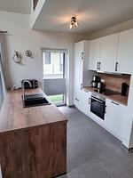 Moderne Küche mit Holzarbeitsplatte und Geräten - Ferienhaus Brandungsperle - Top-Hundeurlaub