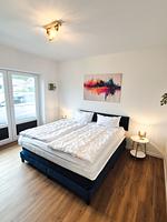 Helles Schlafzimmer mit Doppelbett und Nachttischen. - Ferienhaus Kuestenliebe - Top-Hundeurlaub