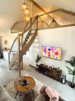 Modernes Wohnzimmer mit Treppe und Fernseher - Ferienhaus Kuestenliebe - Top-Hundeurlaub