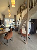 Moderner Wohnraum mit Treppe und großen Fenstern. - Ferienhaus Seestern - Top-Hundeurlaub