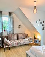 Gemütlicher Wohnraum mit Sofa und Fenster. - Ferienhaus Lea - Top-Hundeurlaub