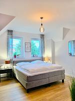 Schlafzimmer mit Doppelbett und Fenstern. Helle Einrichtung. - Ferienhaus Lea - Top-Hundeurlaub