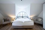Helles Schlafzimmer mit Doppelbett und Sessel - Sanddornhus - Top-Hundeurlaub