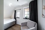 Schlafzimmer mit Bett und Sessel - Sanddornhus - Top-Hundeurlaub