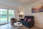 Wohnbereich und Sofa mit elektrischer Liegefunktion - Ferienwohnung Meeresbrise - Top-Hundeurlaub