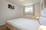 2. Schlafzimmer mit Doppelbett und TV - Reethaus 19a - Top-Hundeurlaub