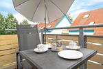 Balkon mit 2 Stühlen, Tisch und einem Sonnenschirm - Wohnung 4-63 - Top-Hundeurlaub