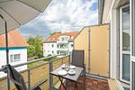 Balkon mit 2 Stühlen, Tisch und einem Sonnenschirm - Wohnung 4-63 - Top-Hundeurlaub